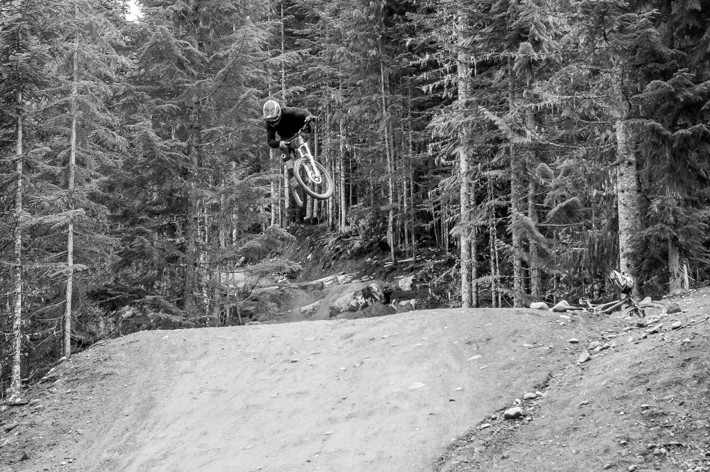 Josh McGarel sending a jump, proving his passion for biking as well as photography on our Bike Park Academy
